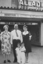 Family standing in front of the theatre sign